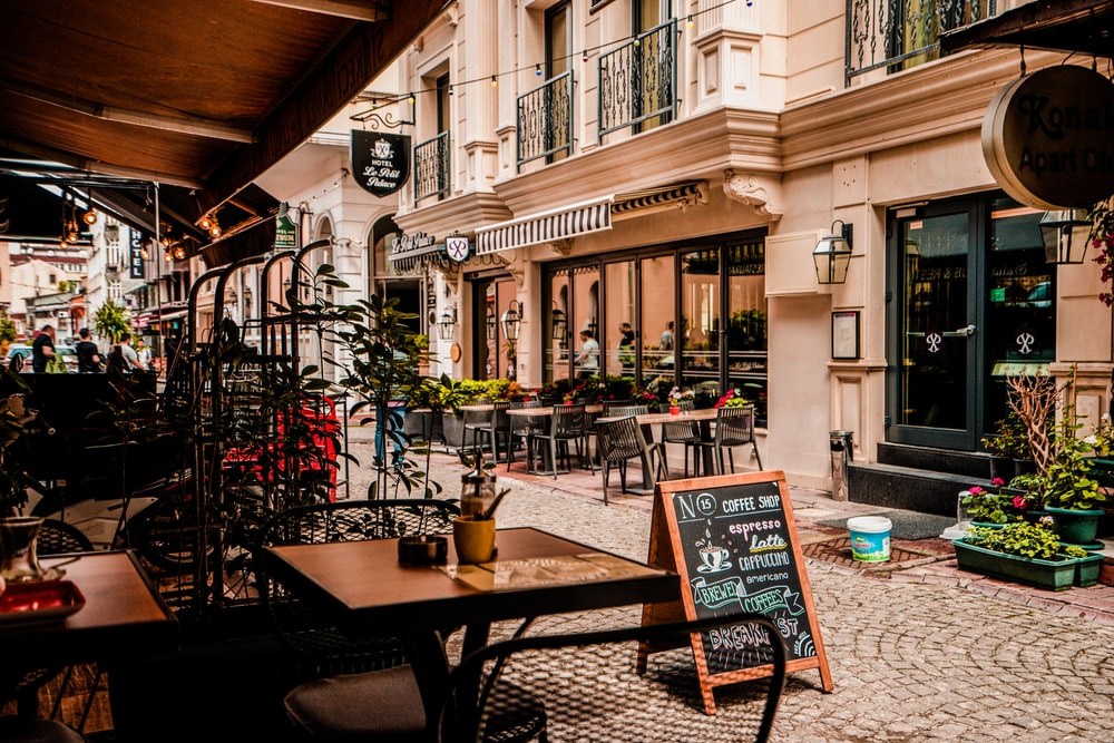 Street café terrace with tables and a coffee menu chalkboard