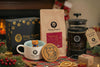 Tiny Tiger Coffee products including a mug, coffee beans, and a press on a festive table with decorations.